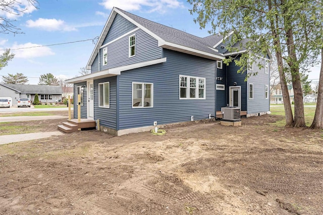 exterior space featuring central AC and roof with shingles