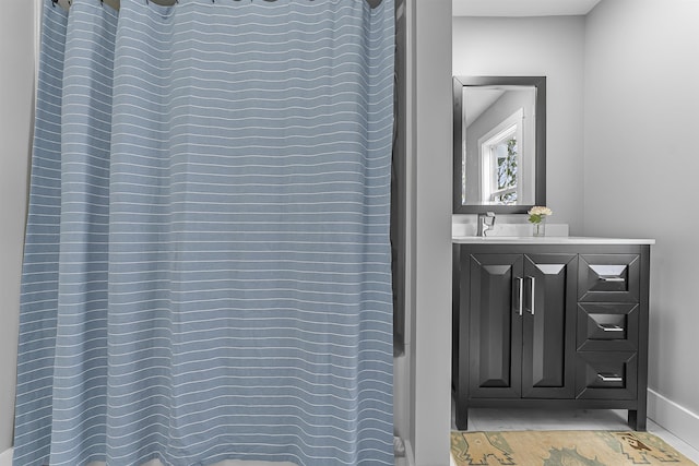 full bath with curtained shower and baseboards