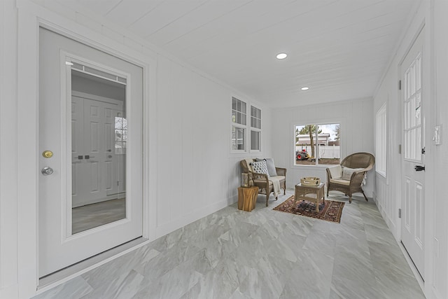 living area with a decorative wall, recessed lighting, and baseboards