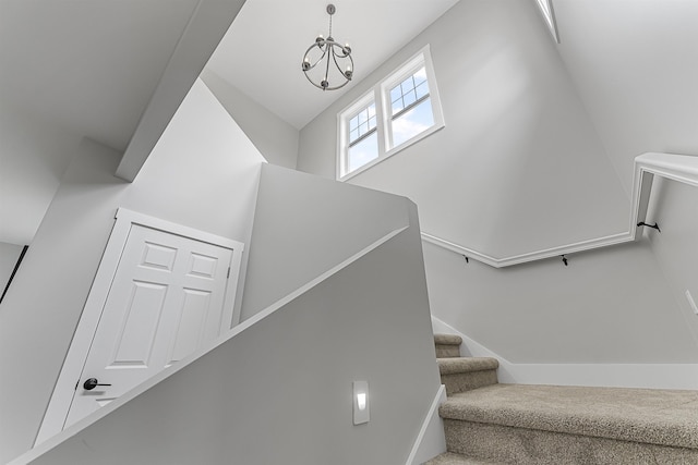 stairs with a notable chandelier