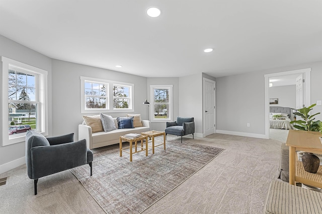 living area featuring baseboards, recessed lighting, visible vents, and light colored carpet