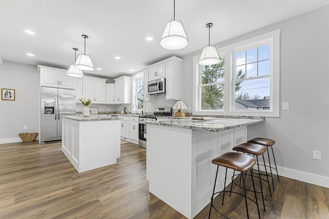 kitchen with white cabinets, appliances with stainless steel finishes, and baseboards