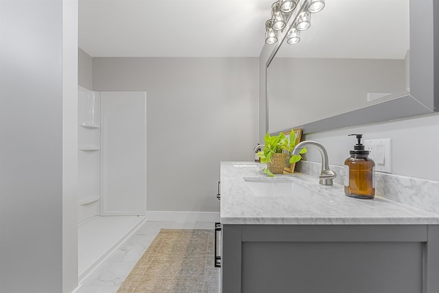 bathroom featuring baseboards, walk in shower, vanity, and marble finish floor