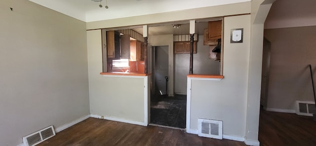 empty room with baseboards, wood finished floors, and visible vents