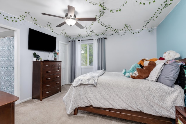 bedroom with light colored carpet, ceiling fan, and baseboards
