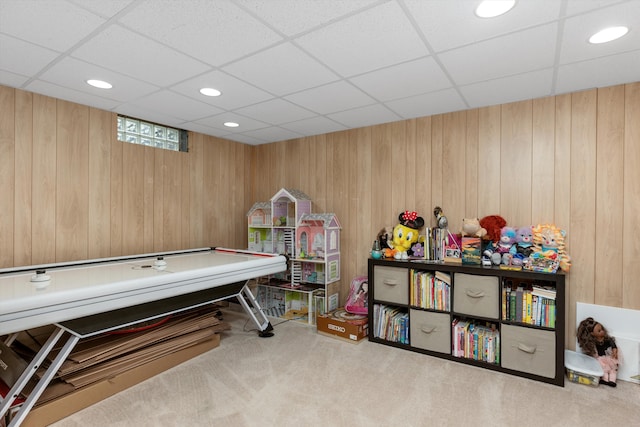 playroom featuring wooden walls, carpet floors, a drop ceiling, and recessed lighting