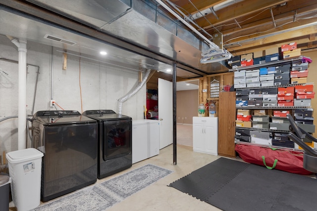 unfinished basement featuring washing machine and clothes dryer and fridge
