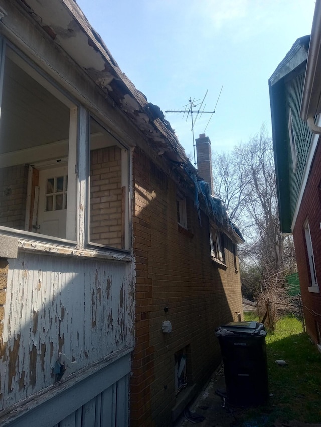 view of home's exterior featuring a chimney and brick siding