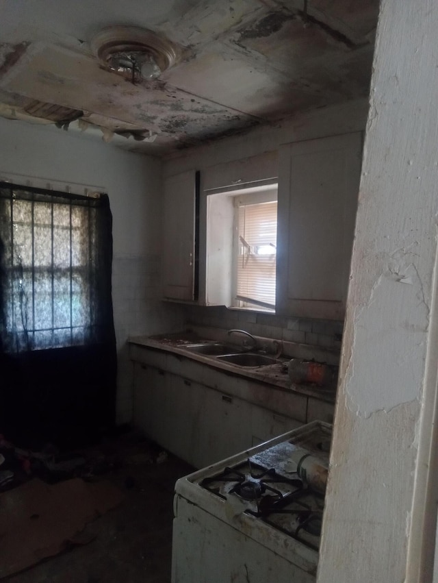 kitchen featuring white gas range oven and a sink