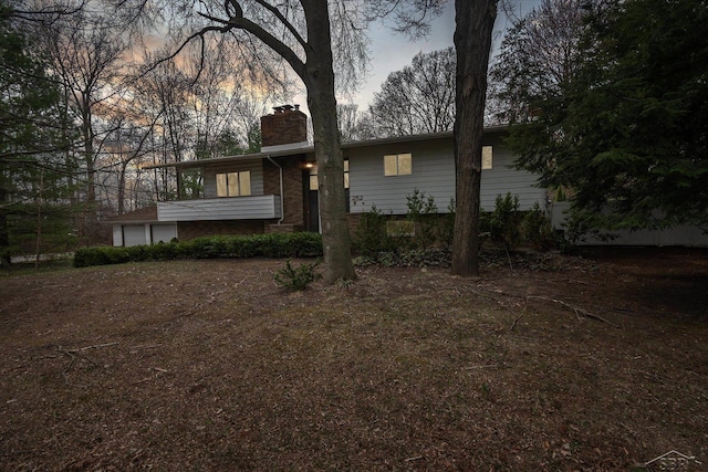 view of front of home featuring a chimney and a garage