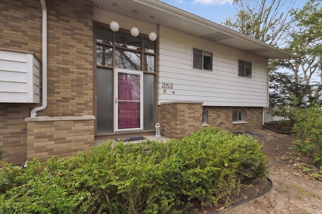 property entrance featuring brick siding