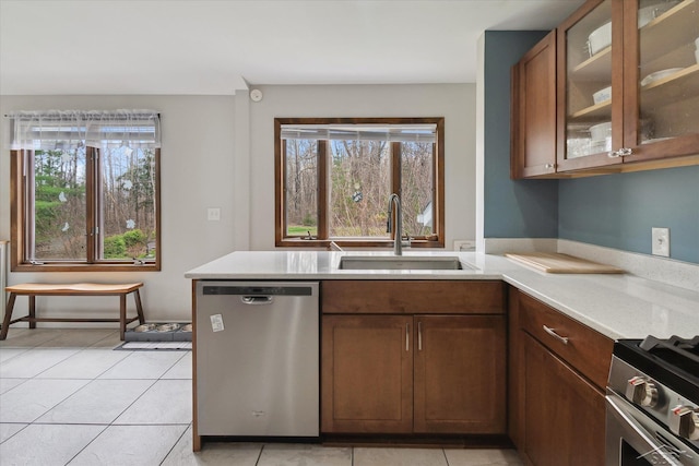 kitchen with a wealth of natural light, stainless steel appliances, light countertops, and a sink