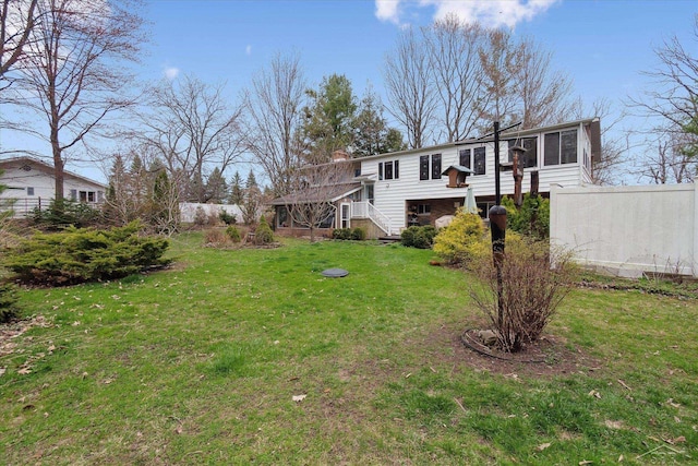 view of yard featuring stairway, fence, and a sunroom