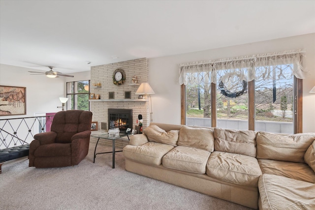 carpeted living area with ceiling fan and a brick fireplace