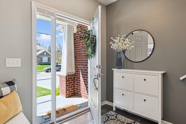 entryway featuring baseboards and wood finished floors