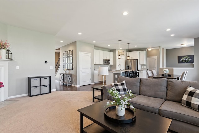 living room with recessed lighting, baseboards, dark carpet, and stairs