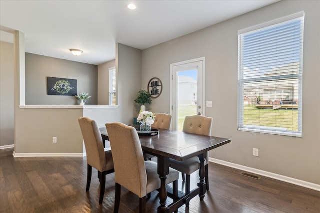 dining space featuring visible vents, baseboards, plenty of natural light, and dark wood-style floors