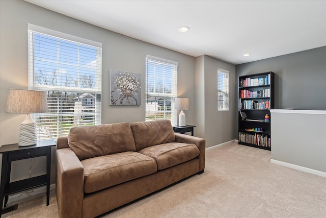 carpeted living area featuring recessed lighting and baseboards