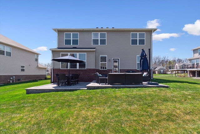 back of property featuring a lawn, a patio, outdoor lounge area, and brick siding