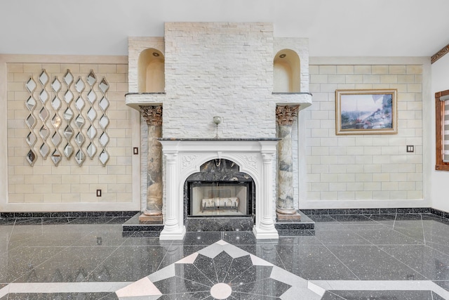 unfurnished living room featuring granite finish floor and a fireplace