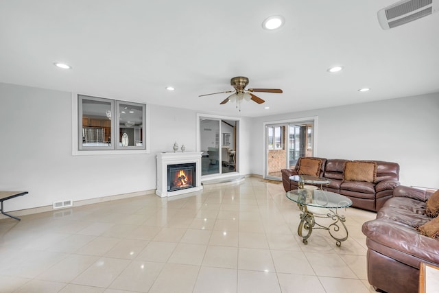 living room featuring a glass covered fireplace, visible vents, and recessed lighting
