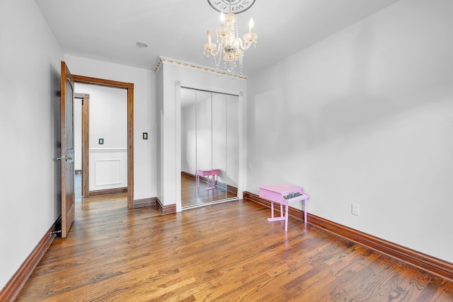 unfurnished bedroom featuring an inviting chandelier, baseboards, and a closet