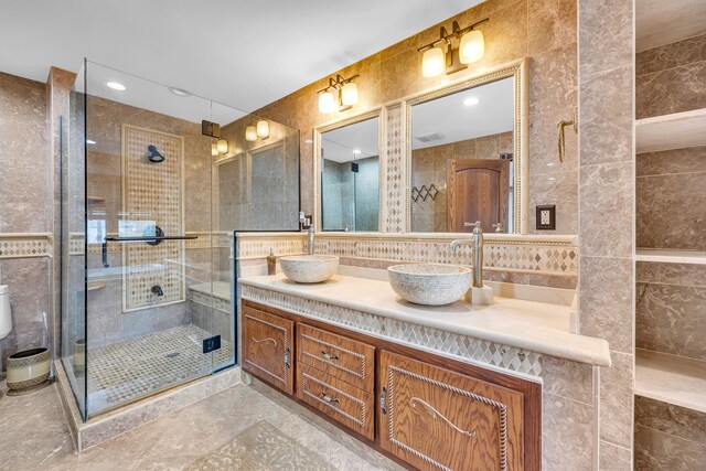bathroom with a stall shower, tile walls, and a sink