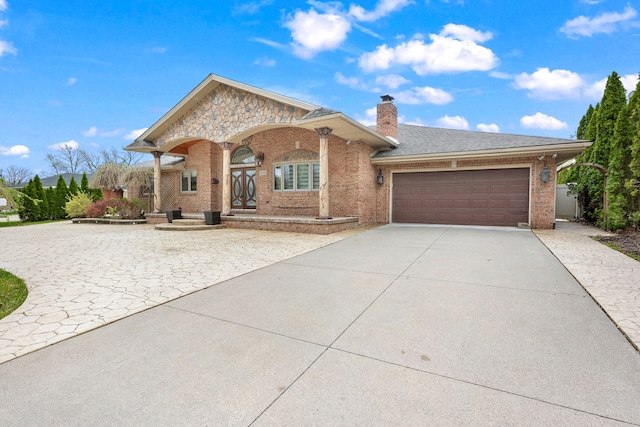 view of front of home featuring a garage, brick siding, covered porch, driveway, and a chimney