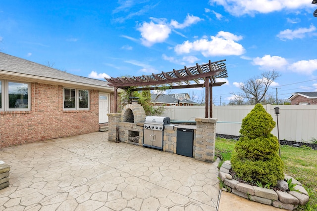 view of patio / terrace with fence, exterior kitchen, area for grilling, and a pergola