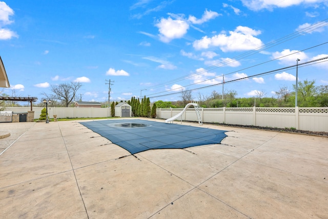view of pool featuring a fenced in pool, a water slide, a patio, and a fenced backyard