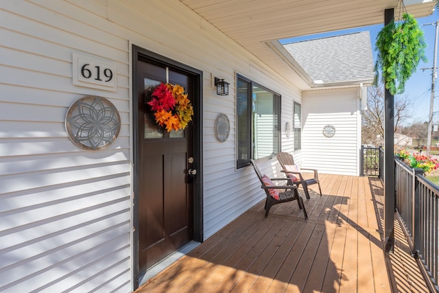 exterior space with a porch and roof with shingles