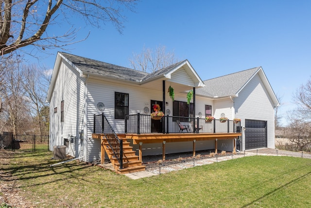 view of front of home featuring fence, a garage, driveway, cooling unit, and a front yard