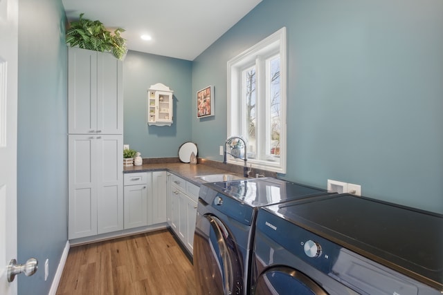 laundry area with a sink, light wood-style floors, washer and dryer, recessed lighting, and cabinet space