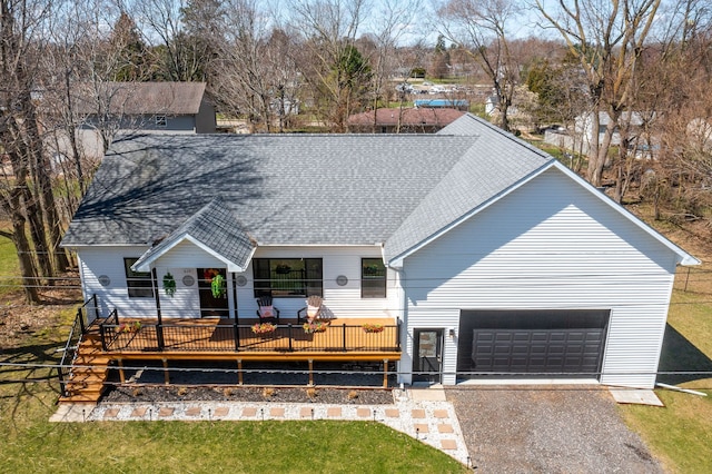 view of front facade with a front lawn, a garage, aphalt driveway, and roof with shingles