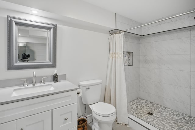 bathroom with vanity, toilet, and a shower stall