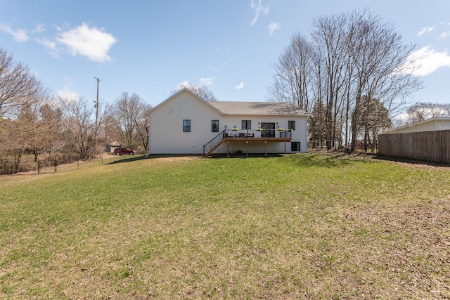 rear view of house featuring a deck, fence, a yard, and stairs