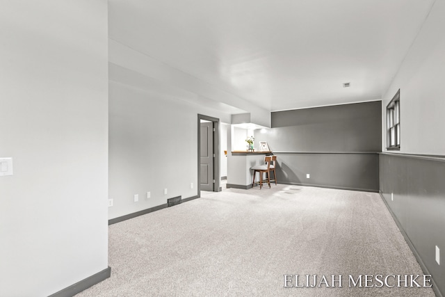 empty room featuring visible vents, carpet, and baseboards