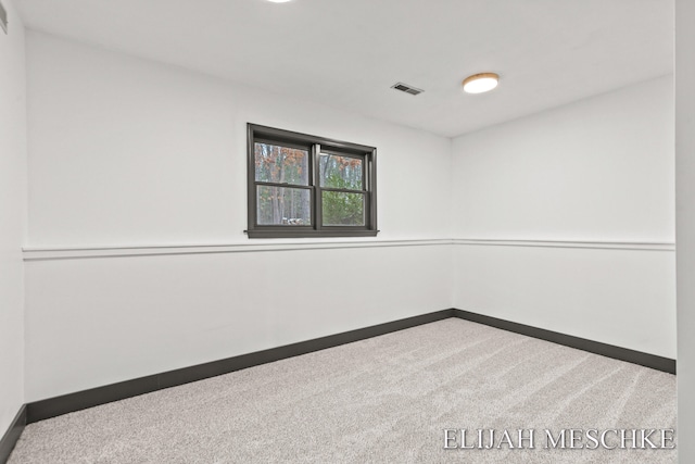 carpeted spare room featuring baseboards and visible vents
