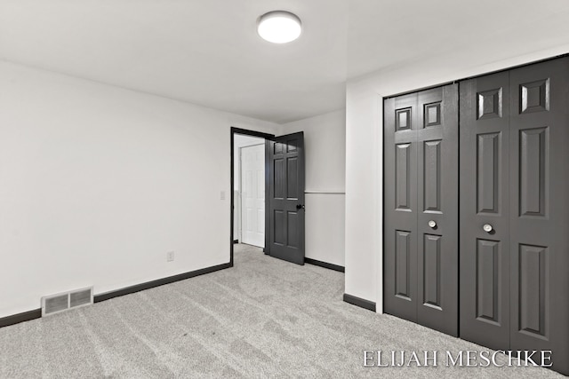 unfurnished bedroom with a closet, visible vents, carpet, and baseboards