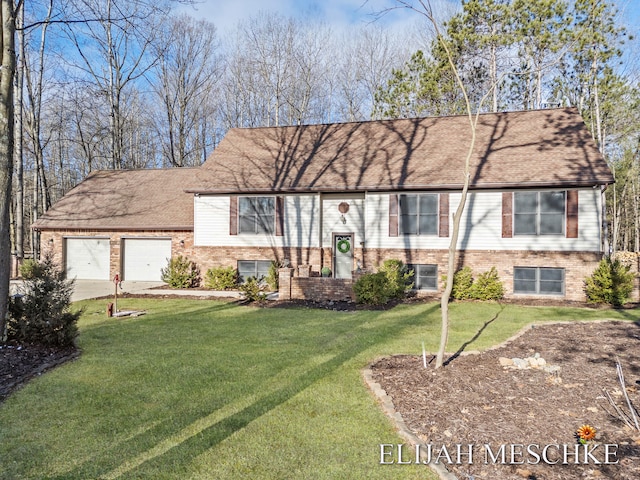 raised ranch with a front yard, driveway, an attached garage, and brick siding