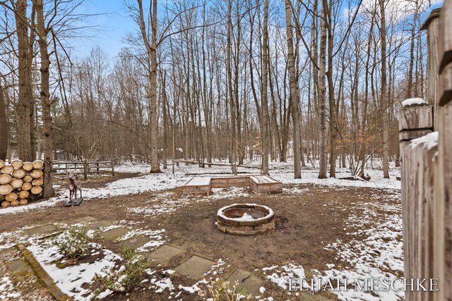 yard covered in snow with a fire pit