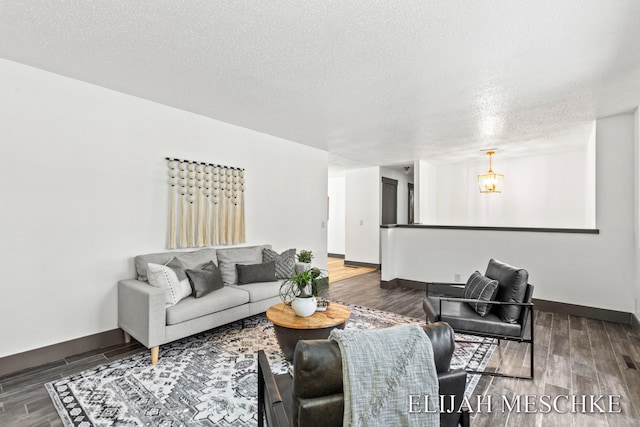 living room featuring baseboards, wood finished floors, and a textured ceiling
