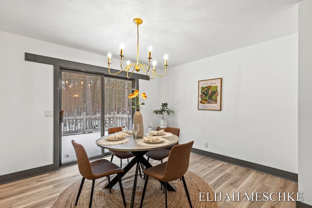 dining area with a chandelier, baseboards, and light wood-style flooring