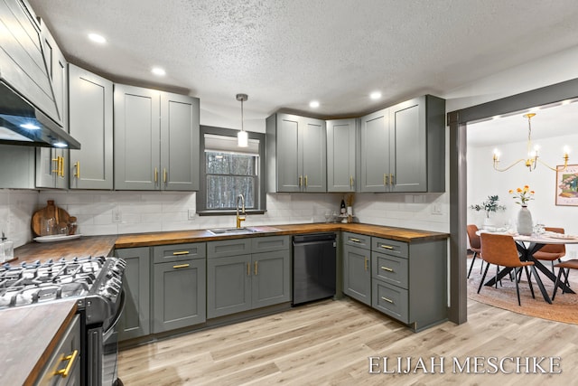 kitchen with wood counters, dishwashing machine, black range with gas cooktop, and a sink