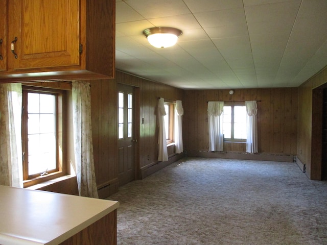 carpeted foyer featuring a baseboard heating unit and wood walls