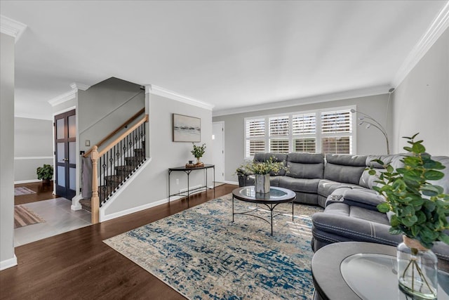 living room with crown molding, baseboards, stairs, and wood finished floors