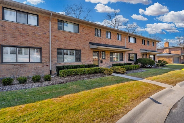 townhome / multi-family property featuring brick siding and a front yard