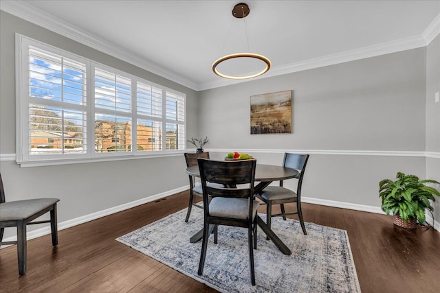 dining area featuring baseboards, ornamental molding, and hardwood / wood-style floors