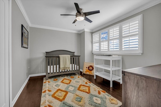 bedroom with crown molding, baseboards, and wood finished floors