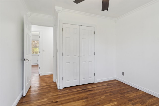 unfurnished bedroom featuring ornamental molding, a closet, wood finished floors, and baseboards